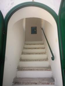 ein Torbogen, der zur Treppe in einem Gebäude führt in der Unterkunft Torre d'Oriente in Rodi Garganico