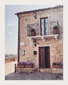 a building with a balcony and a door and flowers at ANPEMO Casa Vacanze in Silvi Paese