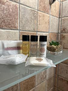 tres productos sentados en una estantería de cristal en un baño en ANPEMO Casa Vacanze, en Silvi Paese
