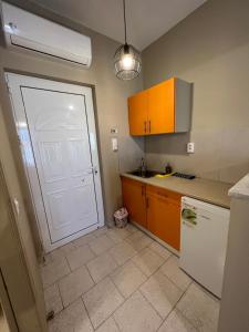 a kitchen with a white door and a white refrigerator at Ilaeira rooms in Argasi