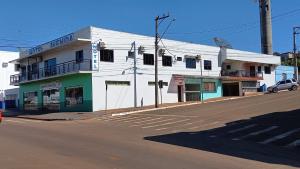 a white building on the corner of a street at Hotel Avenida - Hotel do Morais - Salto do Lontra in Salto do Lontra
