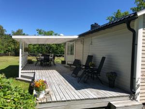 una terraza de madera con sillas y pérgola en Lugnt läge i Färjestaden en Färjestaden