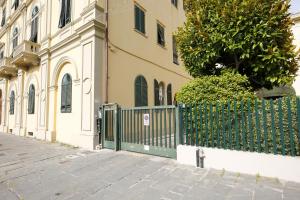 a green fence in front of a building at Lungarno Buozzi 7 Apartments in Pisa