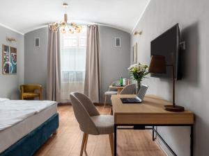 numa I Libusa Apartments في براغ: غرفة نوم مع سرير ومكتب مع الكمبيوتر المحمول