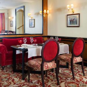 a restaurant with two tables and chairs with wine glasses at NARUTIS hotel in Vilnius