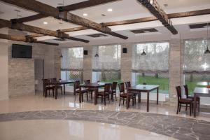 a dining room with tables and chairs and windows at Ladoga Hotel in Petrozavodsk