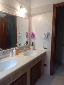 a bathroom with two sinks and a large mirror at Il Roseto in Coppito +25 photos