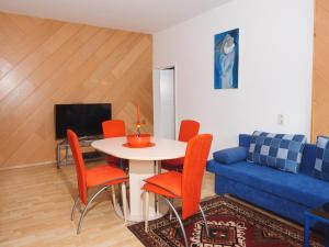 a living room with a table and chairs and a blue couch at Holiday Apartment Nana in Reichenfels