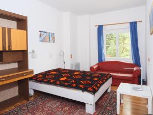 a bedroom with a bed and a couch and a window at Holiday Apartment Nana in Reichenfels