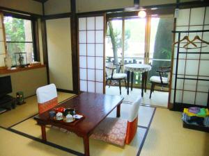 a living room with a table and chairs and a table at Sumiyoshi Ryokan in Takayama