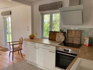 a kitchen with white cabinets and a stove top oven at Ferienhaus Leezen in Leezen