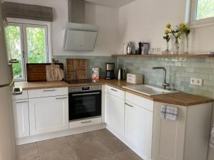 a kitchen with white cabinets and a sink at Ferienhaus Leezen in Leezen