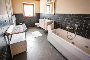a bathroom with a tub and a toilet and a sink at La Marmote Albergo Diffuso di Paluzza San Nicolò in Paluzza