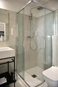 a bathroom with a shower with a toilet and a sink at Hôtel Continental in Bastia