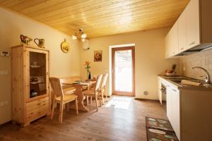 eine Küche und ein Esszimmer mit einem Tisch und Stühlen in der Unterkunft La Marmote Albergo Diffuso di Paluzza San Nicolò in Paluzza