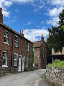 an old brick building with a road in front of it at Church View, dog friendly, with parking, in Bolton Percy