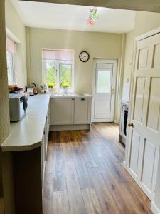 a kitchen with a counter and a clock on the wall at Church View in Bolton Percy +11 photos