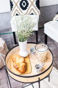 een tafel met een dienblad met eten en een vaas met bloemen bij SuperApart Kocjana in Warschau