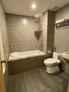 a bathroom with a tub and a toilet and a sink at LANA INN - Grand World Phú Quốc in Phu Quoc