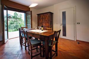 una sala da pranzo con tavolo e sedie in legno di La Marmote Albergo Diffuso di Paluzza Testeons Nord a Paluzza