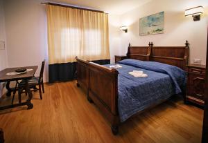 una camera con letto, tavolo e sedia di La Marmote Albergo Diffuso di Paluzza Testeons Nord a Paluzza