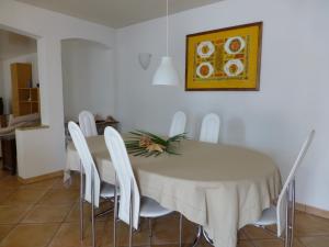 uma sala de jantar com uma mesa e cadeiras brancas em Casa Chatelain em Ronco sopra Ascona