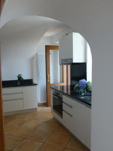 une cuisine avec des placards blancs et un comptoir noir dans l'établissement Casa Chatelain, à Ronco sopra Ascona