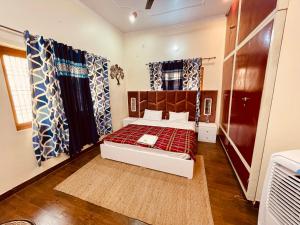a bedroom with a bed and curtains in a room at Stayble Homestay in Dehradun