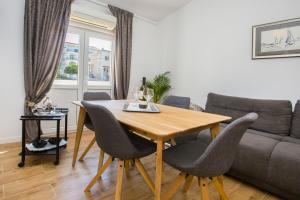 een woonkamer met een houten tafel en stoelen bij Situs Katarina in Trogir