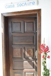 eine Holztür mit einem Schild darüber in der Unterkunft Casa SocAire. Naturaleza, mar, paz, relax. in Tabayesco