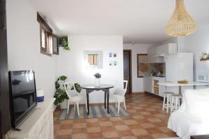 ein Wohnzimmer und eine Küche mit einem Tisch und Stühlen in der Unterkunft Casa SocAire. Naturaleza, mar, paz, relax. in Tabayesco