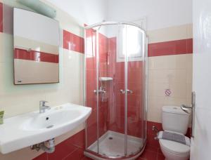 uma casa de banho com um chuveiro, um lavatório e um WC. em Cyclades Blue em Ornos