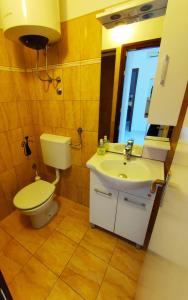 a bathroom with a toilet and a sink and a window at Apartmani David in Pula +15 photos