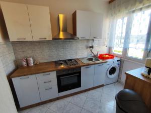 a kitchen with a stove and a washing machine at Apartmani David in Pula