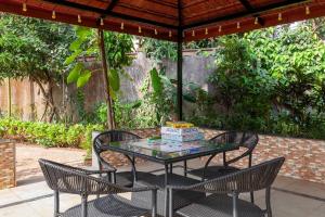 Una mesa con un pastel encima y dos sillas. en Sunshine Bloom by VEO - Part of StayVista, en Lonavala