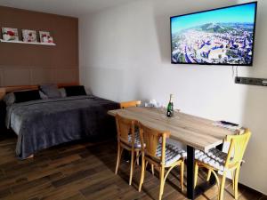 een slaapkamer met een bed en een tafel met stoelen bij Apartmány RŮŽIČKA in Mikulov