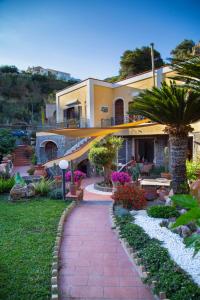 een groot huis met een rode bakstenen loopbrug bij Villa Paradiso in Ischia