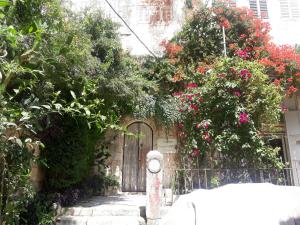 a garden with a gate and a fence with flowers at Soufan Guest HOUSE in Nablus