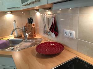um balcão de cozinha com um lavatório e uma tigela vermelha em Apartment Kleeblatt em Hahnenklee-Bockswiese