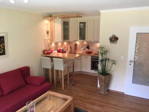 a living room with a red couch and a kitchen at Apartment Kleeblatt in Hahnenklee-Bockswiese