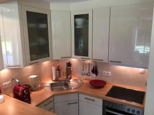 a kitchen with white cabinets and a sink at Apartment Kleeblatt in Hahnenklee-Bockswiese