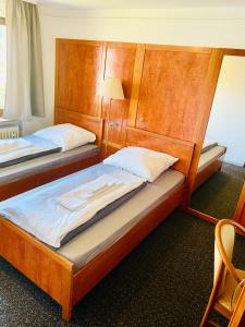 2 camas individuales en una habitación con lámpara en Heiligenröder Pension en Niestetal
