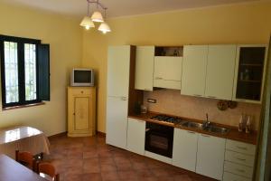 a kitchen with white cabinets and a sink and a microwave at Agriturismo Frangivento in Casa Giosafat