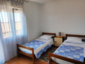a bedroom with two beds and a window at Apartmani David in Pula