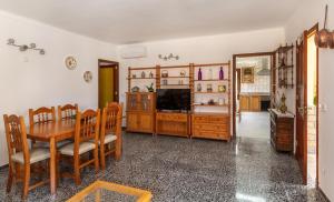 a dining room with a table and a television at Calamar 7 in Portocolom