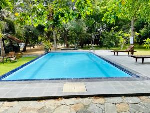 a large blue swimming pool in a park at Kaaya Eco Resort Yala in Tissamaharama