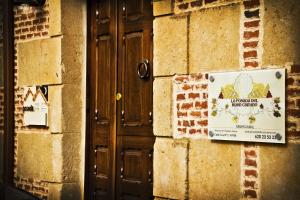 una señal en el lateral de un edificio con una puerta en Posada Real del Buen Camino en Villanueva de Campeán