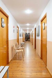 a corridor of a hospital with chairs and tables at Albergue Montes de Anaga in El Bailadero