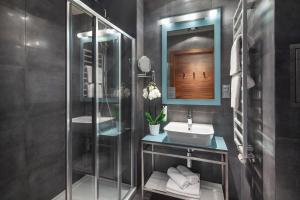 グディニャにあるSea Premium Apartmentsのバスルーム(ガラス張りのシャワー、シンク付)
