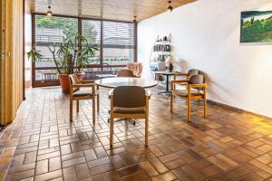 - une salle d'attente avec des tables, des chaises et des fenêtres dans l'établissement Ferienwohnung Fetscher 1, à Île de Reichenau